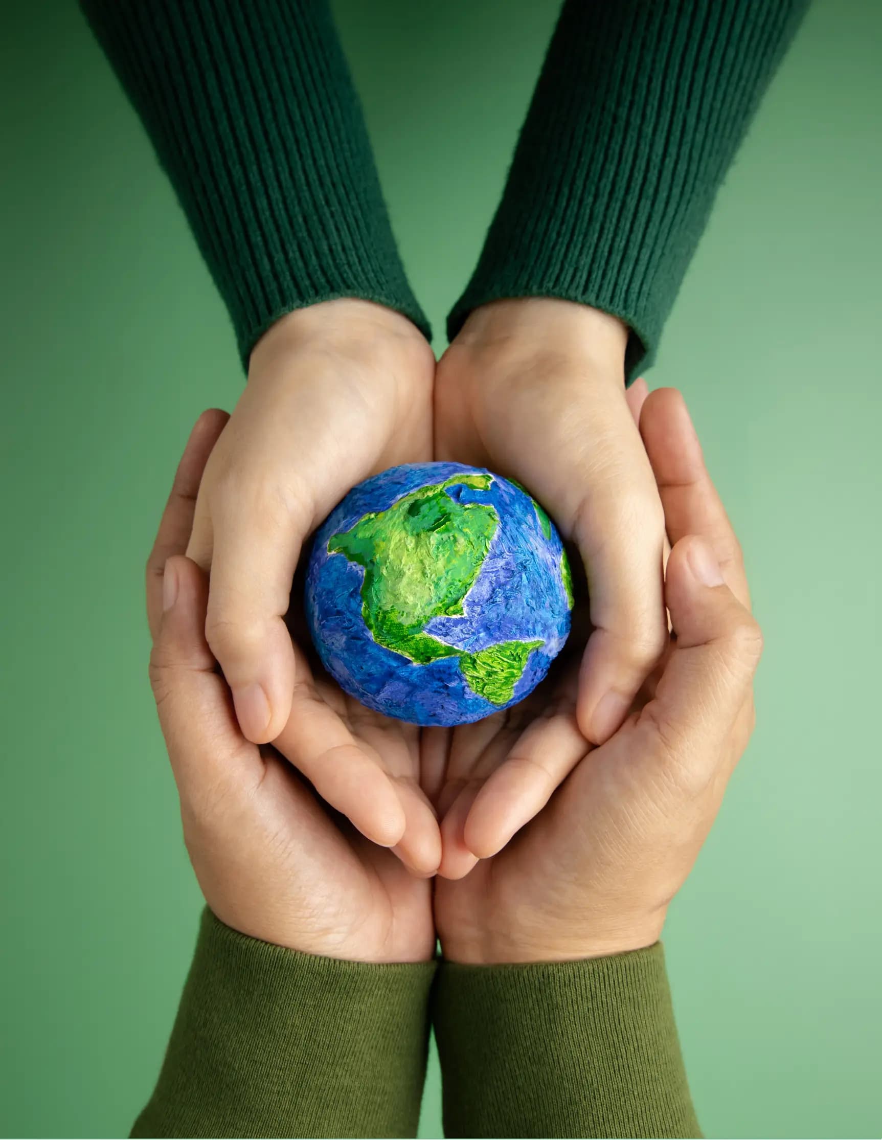 Two hands holding a small globe