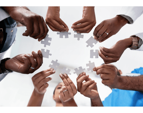 Team members joining puzzle pieces together
