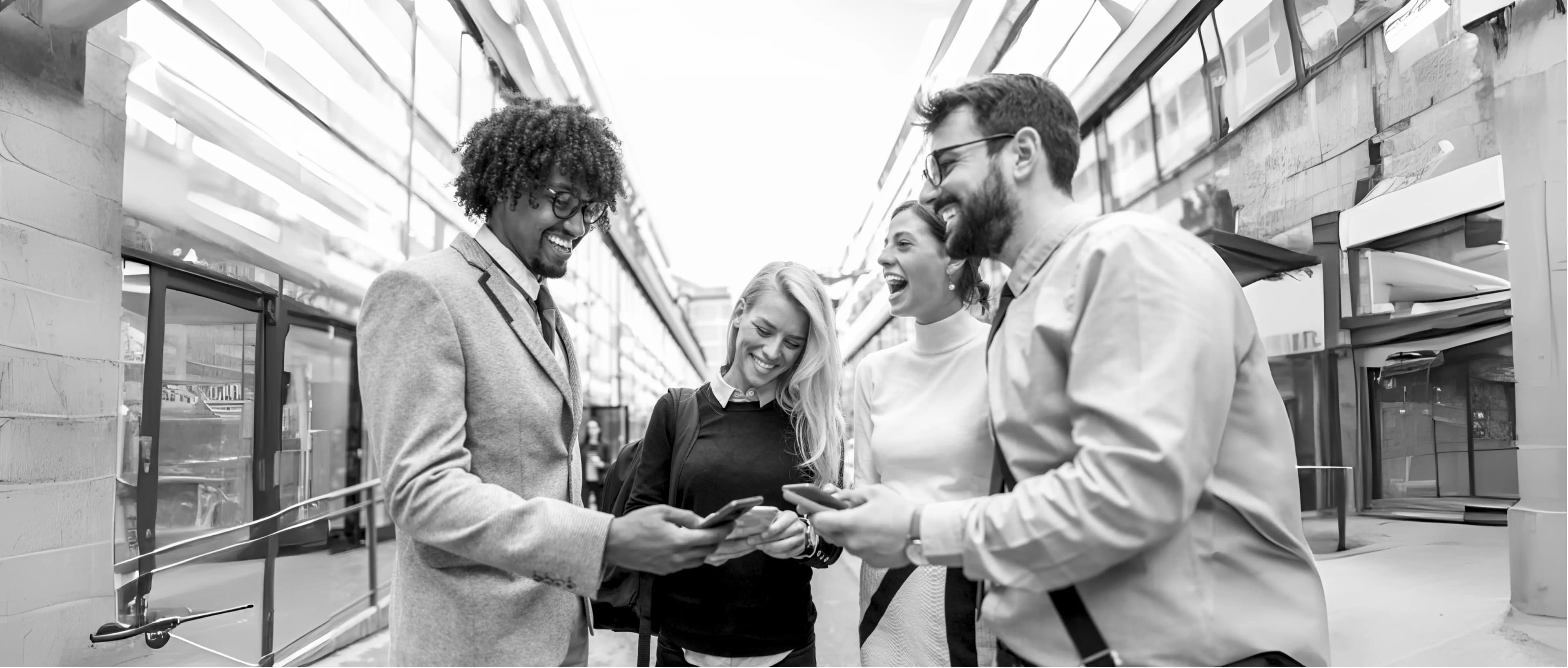 Colleagues smiling and looking at their phones